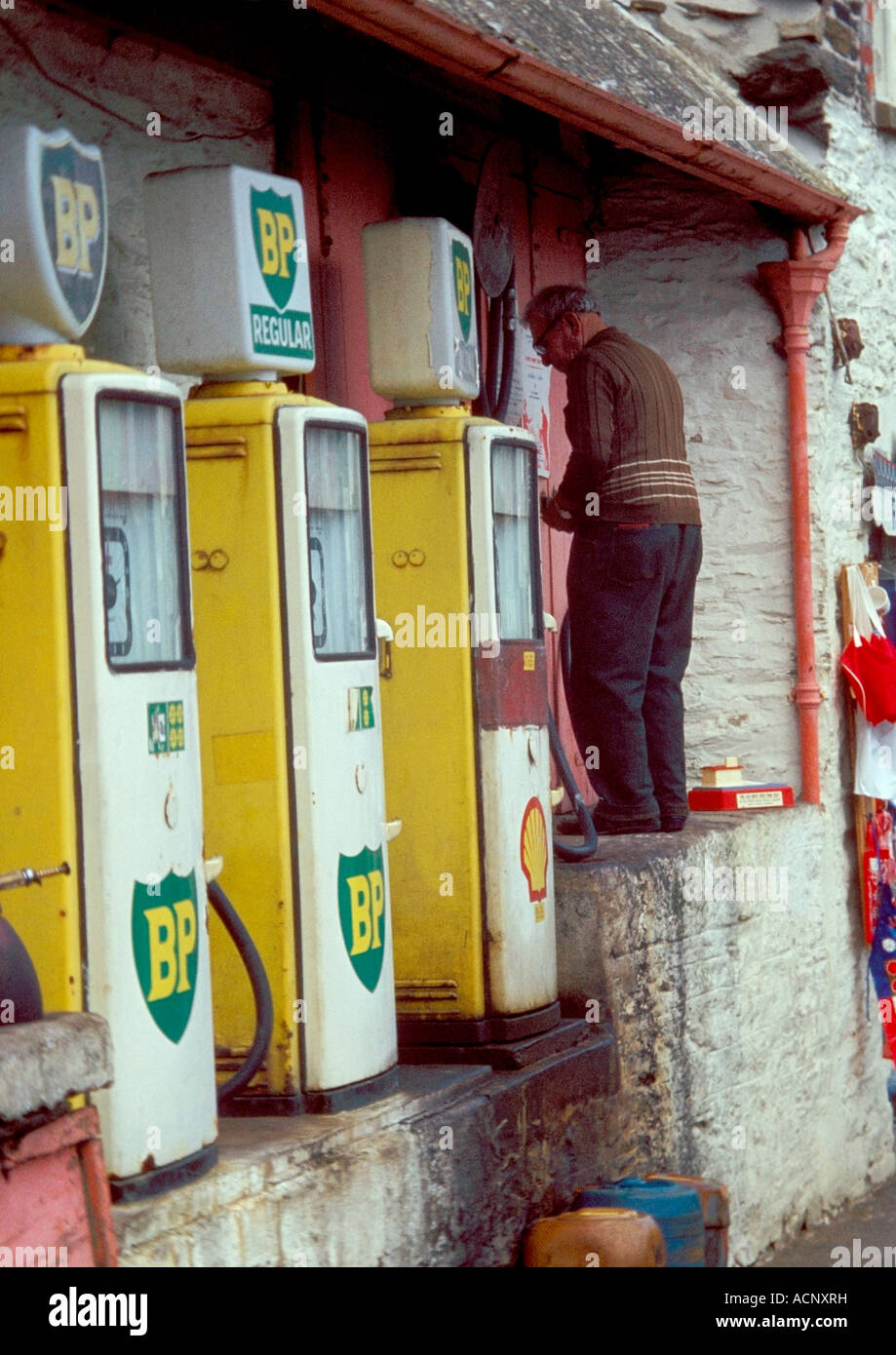Un vecchio uomo tendendo le pompe di benzina Foto Stock