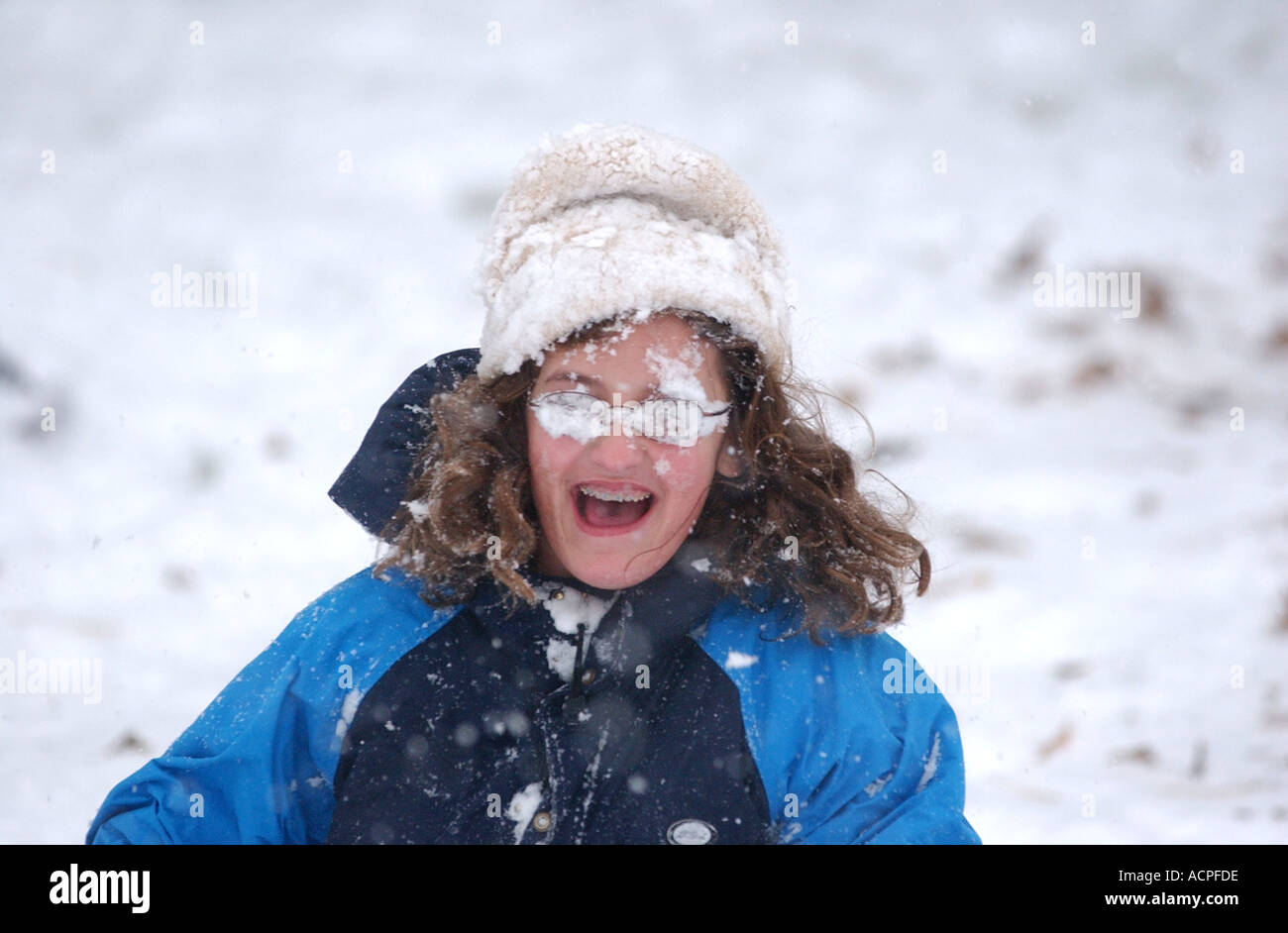 Funny kid picture ragazza con la faccia coperta di neve dopo essere stato colpito da snowball Foto Stock
