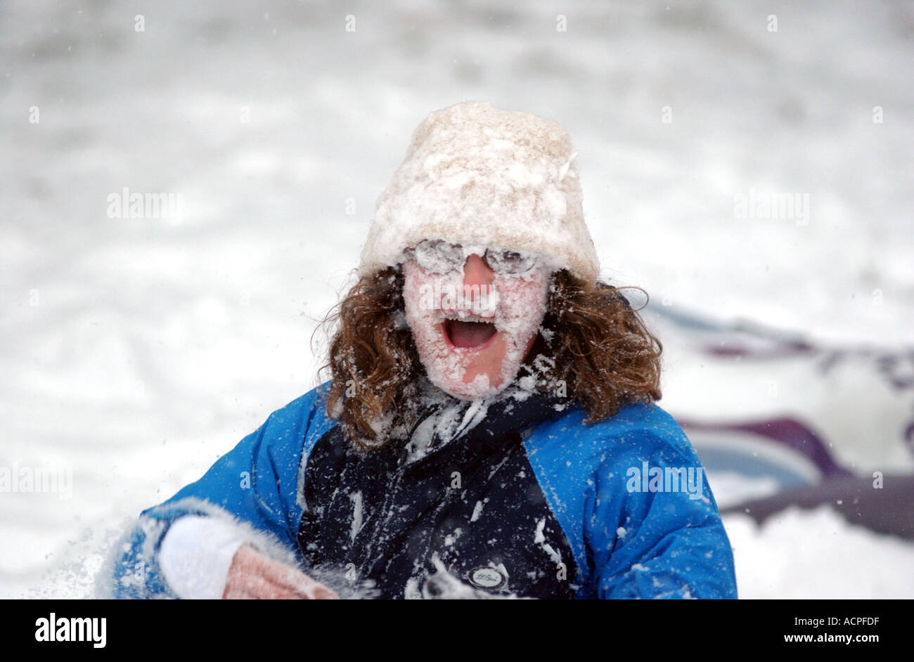 Funny kid picture ragazza con la faccia coperta di neve dopo essere stato colpito da snowball Foto Stock