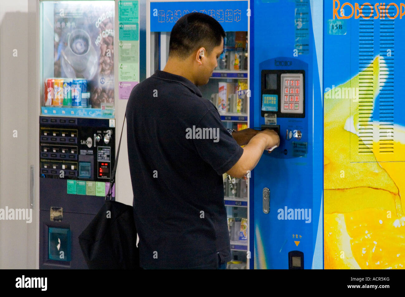 Uomo cinese di acquistare da uno Snack Distributore PVG Aeroporto Internazionale di Pudong Shanghai in Cina Foto Stock