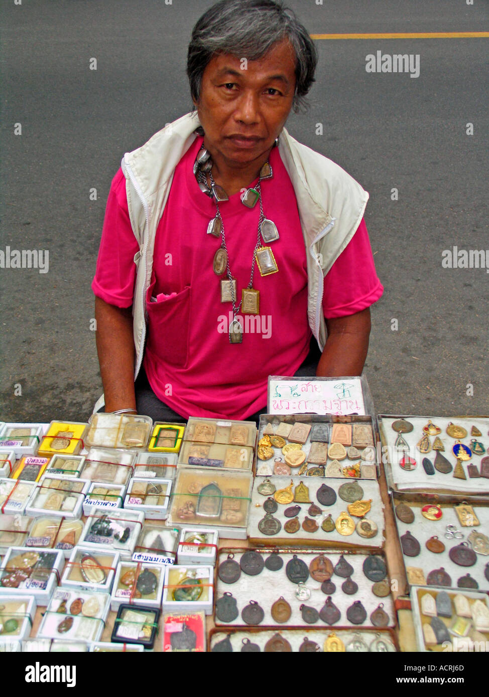 Venditore ambulante indossando amuleti buddisti su collana Thanon Phra Chan mercato amuleto Bangkok in Thailandia Foto Stock