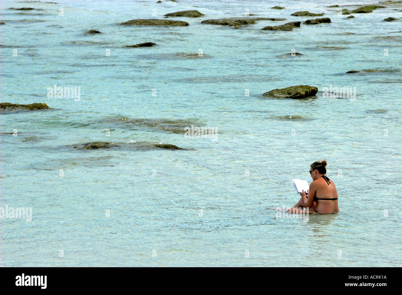 Giovane donna non si raffredda in acqua a lettura spiaggia Prenota Ko Pha Ngan isola della Thailandia Foto Stock