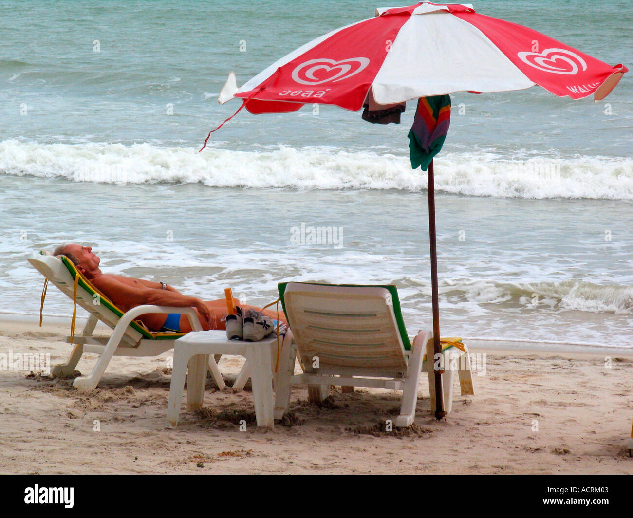 L uomo si rilassa sulle sdraio Patong Beach dopo lo tsunami isola di Phuket Thailandia Foto Stock