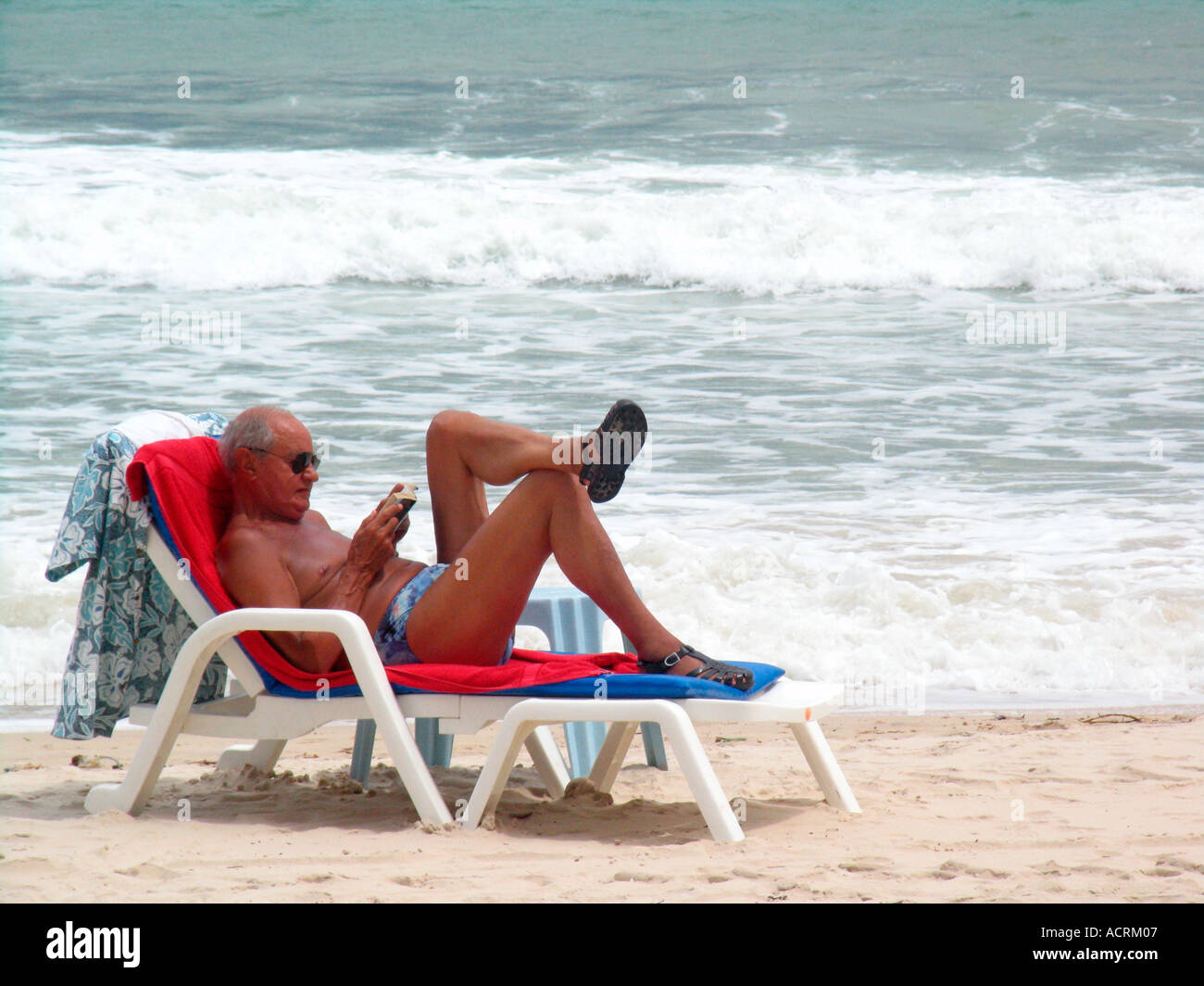 Uomo legge un libro sul prendisole Patong Beach dopo lo tsunami isola di Phuket Thailandia Foto Stock