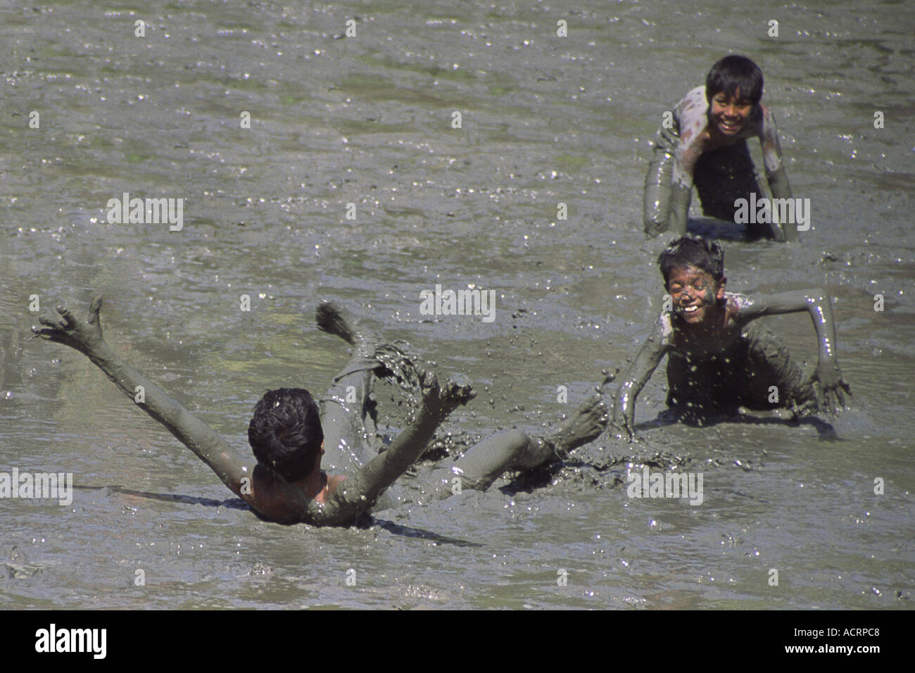 Bengali giocare i bambini nel fango al di fuori di Calcutta, West Bengal, dell' India . Foto Stock