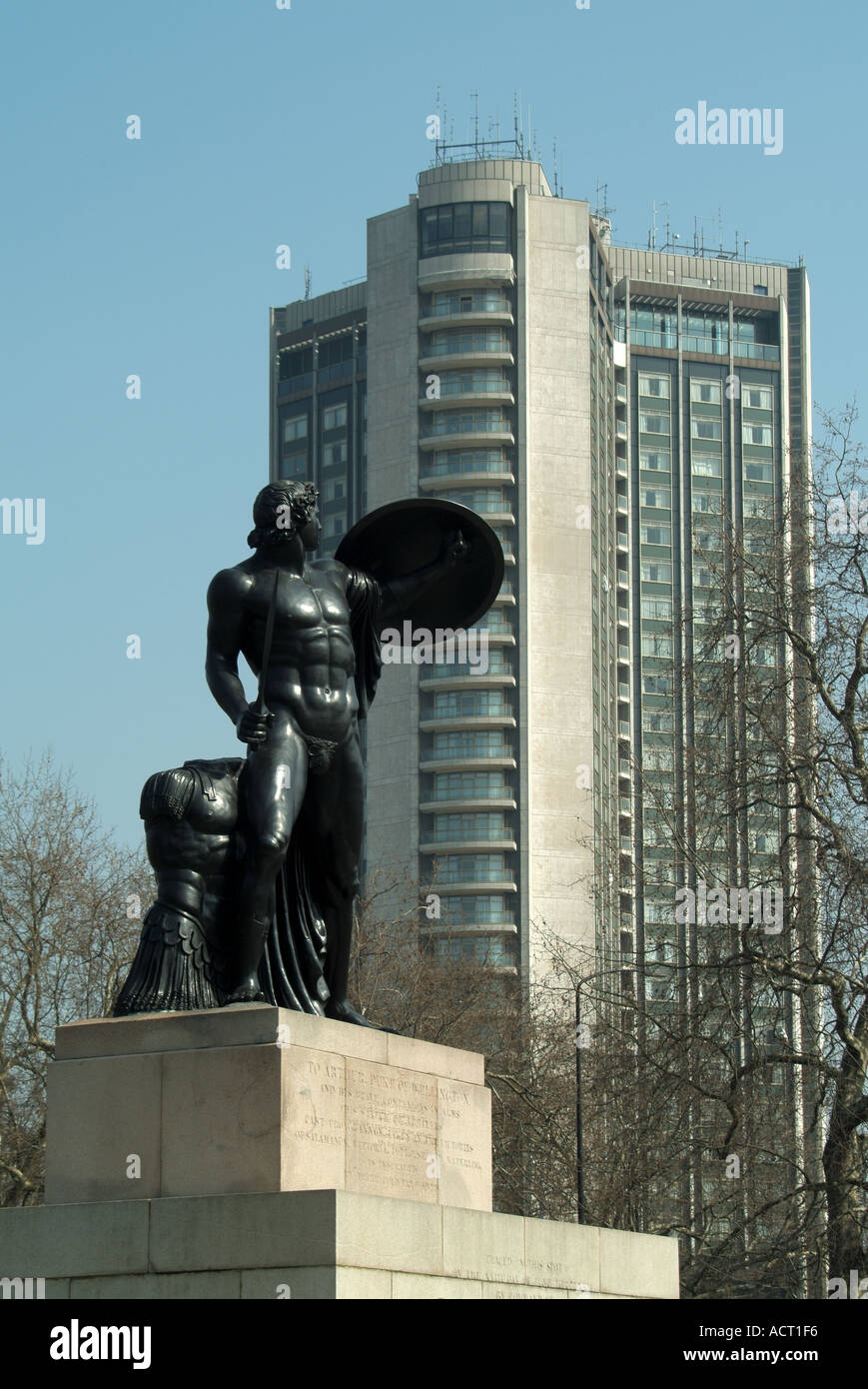 Alberi invernali e primo piano statua di Achille in Hyde Park Commemorando il Duca di Wellington con l'edificio del grattacielo dell'Hilton Hotel Park Lane Londra UK Foto Stock Alberi invernali e primo piano statua di Achille in Hyde Park Commemorando il Duca di Wellington con l'edificio del grattacielo dell'Hilton Hotel Park Lane Londra UK Foto Stock