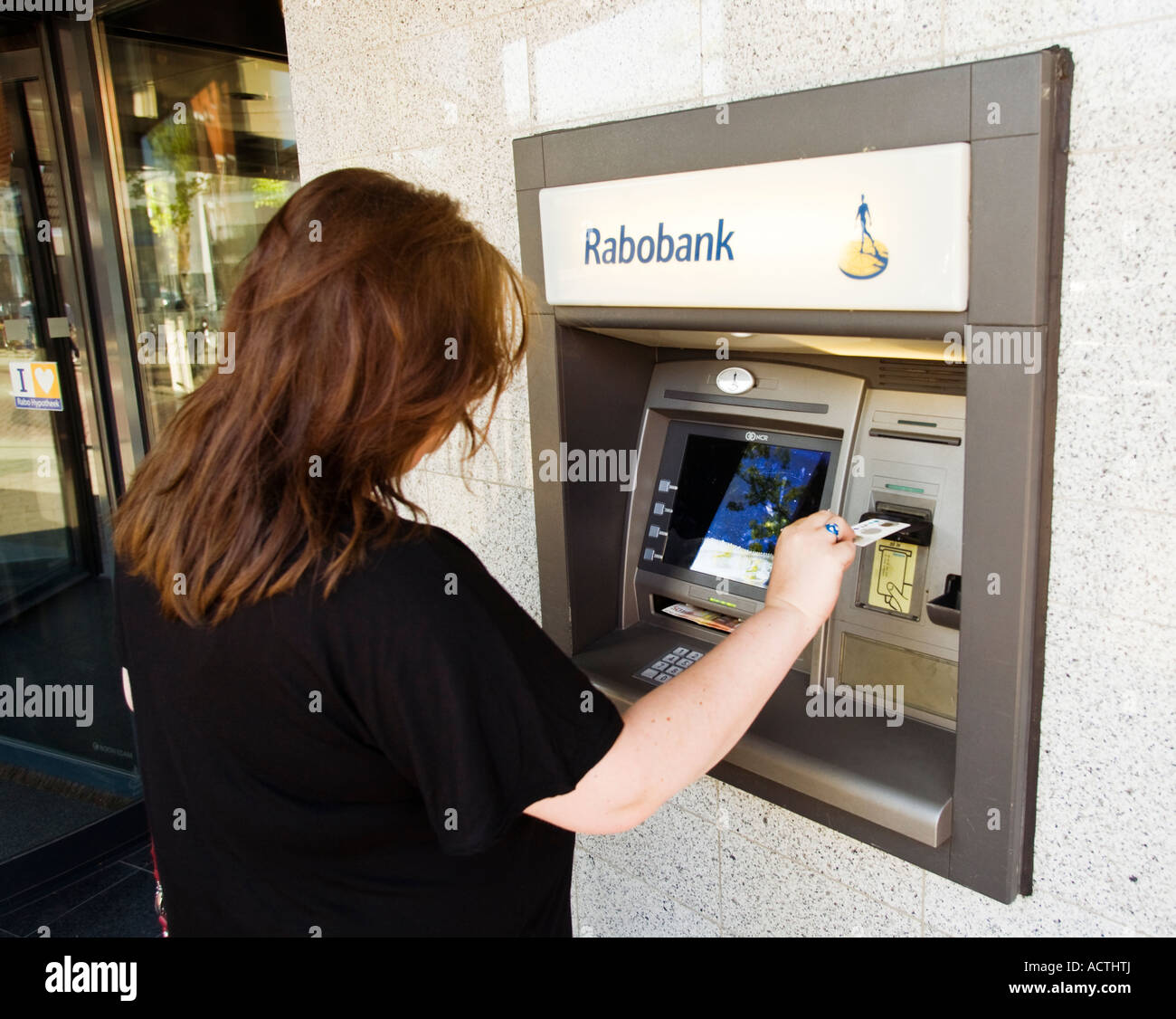 Donna che utilizza un Rabobank bancomat nei Paesi Bassi Foto Stock