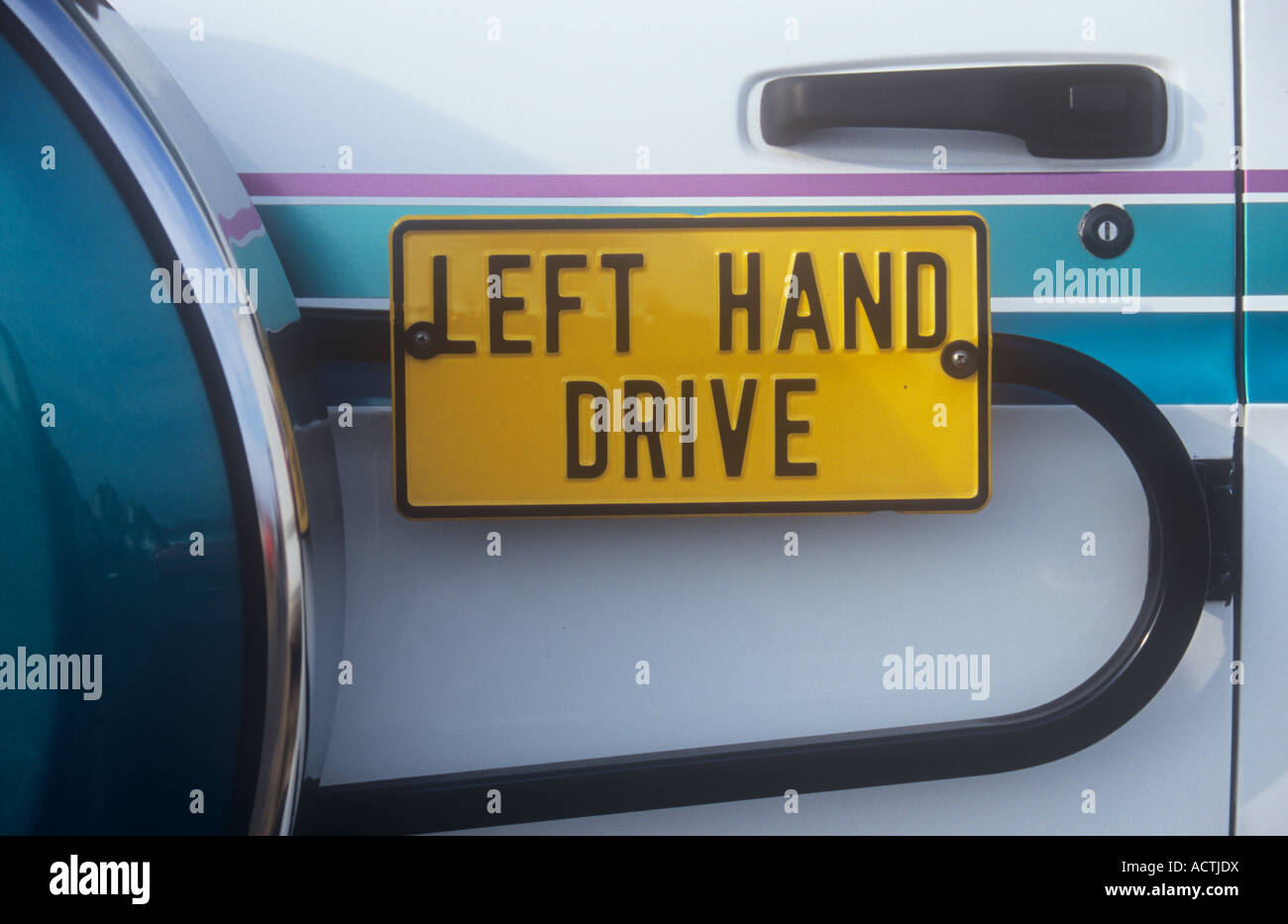 Il giallo e il nero segno sulla parte posteriore del bianco e del turchese di avvertimento veicolo guida a destra utenti della strada che questa ha la guida a sinistra Foto Stock