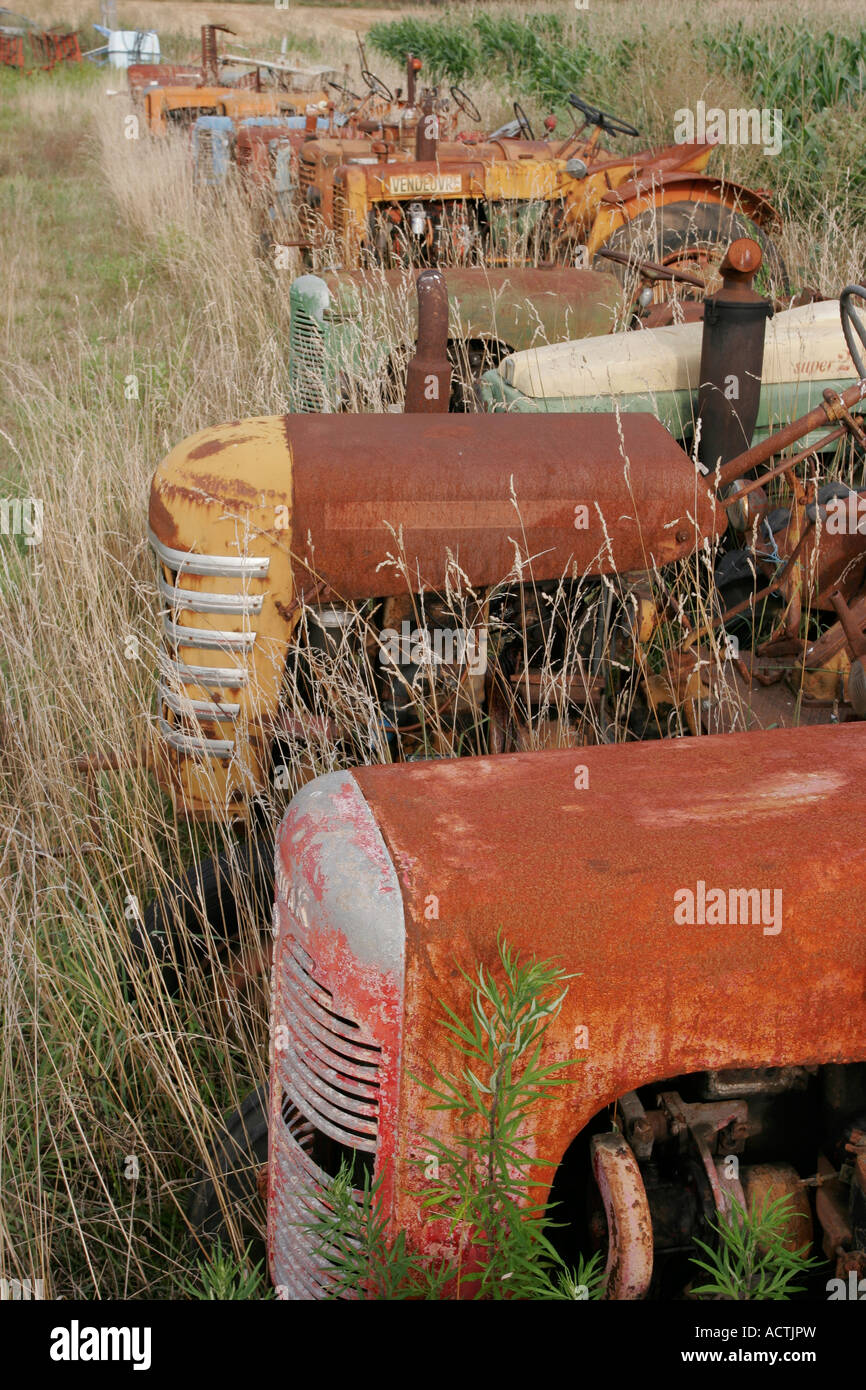 Una fila di rusty vecchia fattoria trattori in Francia Foto Stock