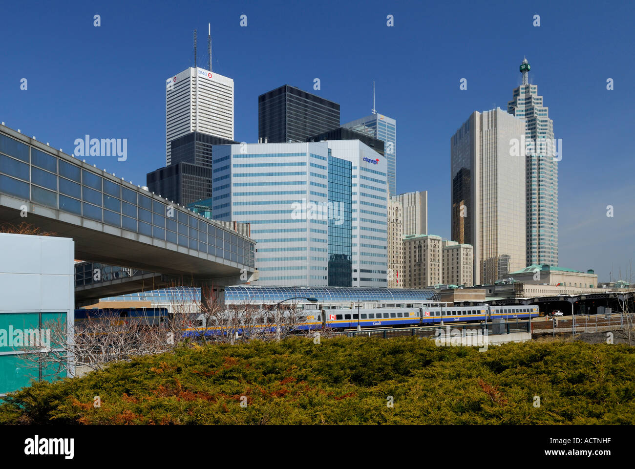VIA treno alla Stazione Union skywalk e Toronto highrise skyline con torri finanziarie Foto Stock