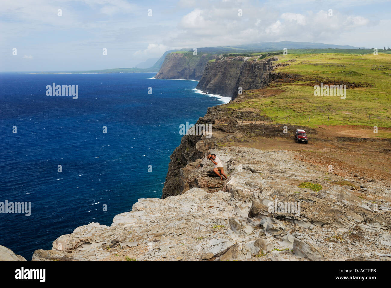 Un turista per fotografare in corrispondenza del bordo di alte scogliere sul mare Isola di Molokai Hawaii Foto Stock