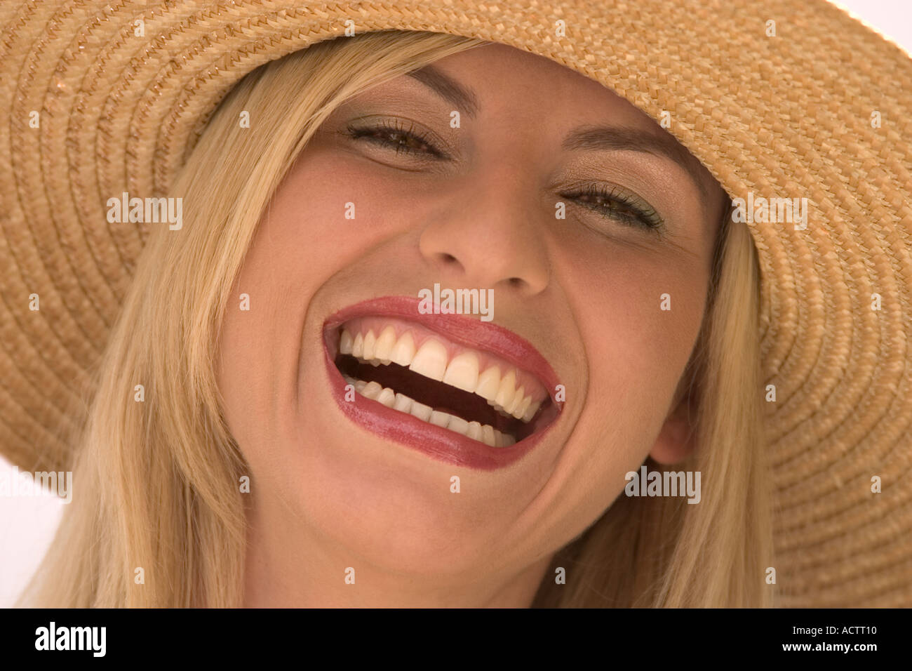 Ridendo donna bionda con cappello di paglia Foto Stock