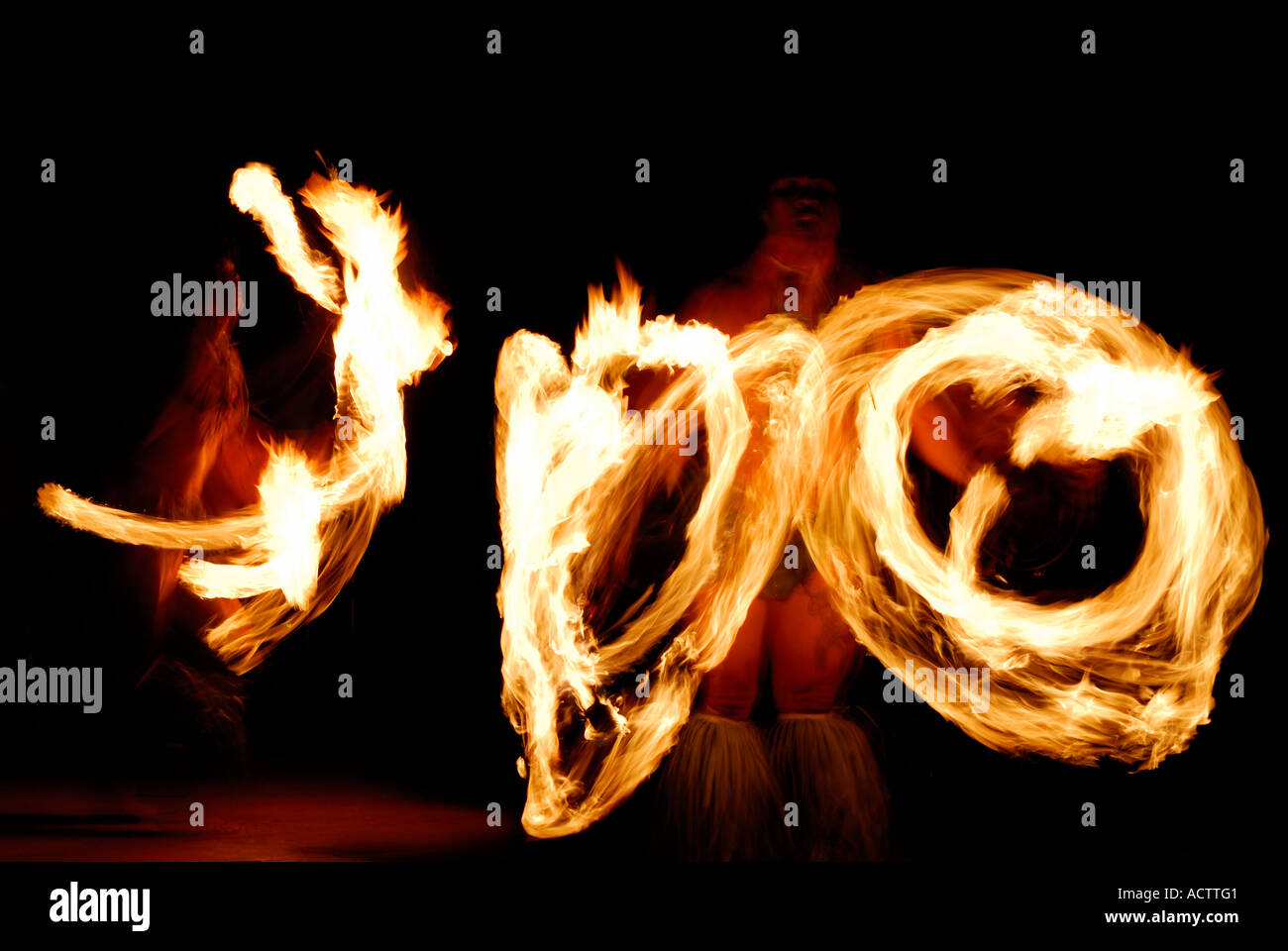 Due danzatori con il fuoco di filatura manganelli illuminata di notte dopo un luau sull'Isola di Maui Hawaii Foto Stock