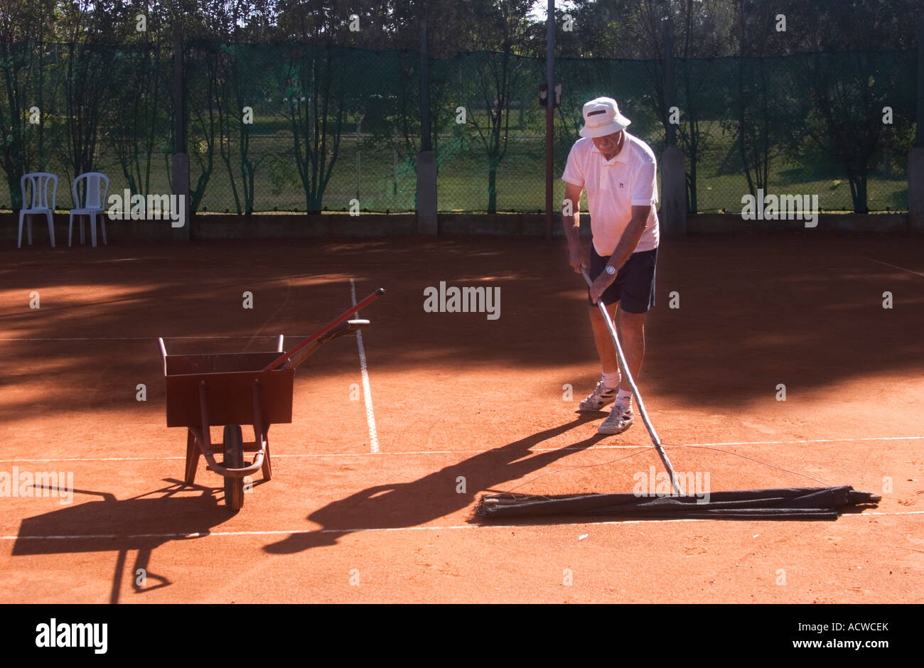 Campo da tennis in terra battuta uomo di manutenzione sul luogo di lavoro Foto Stock
