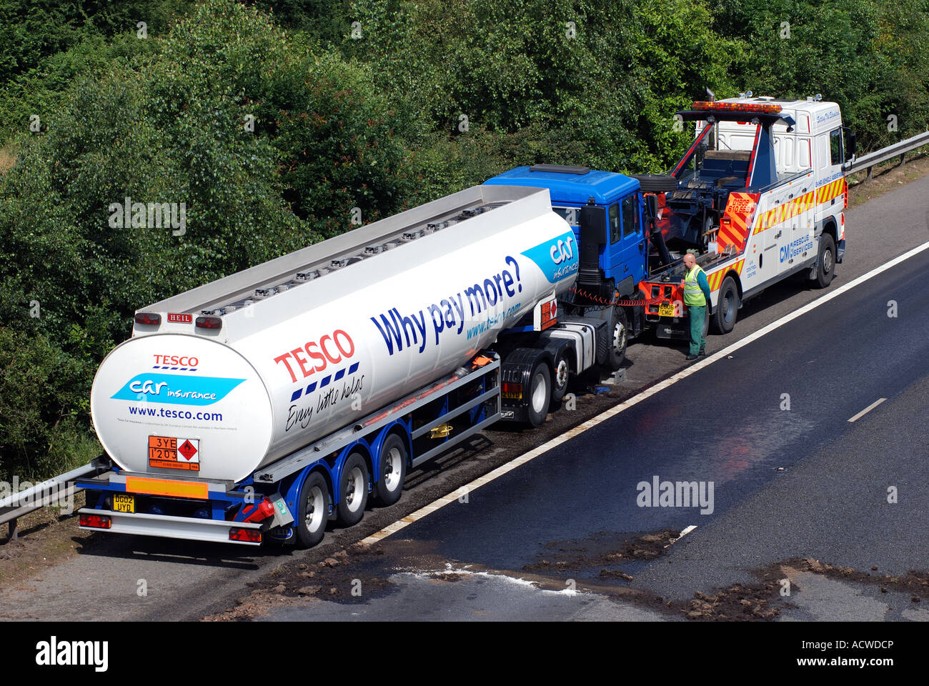 Trainare il carrello con la Tesco tanker avente fuoriuscita di diesel sulla autostrada M40, Warwickshire, Inghilterra, Regno Unito Foto Stock