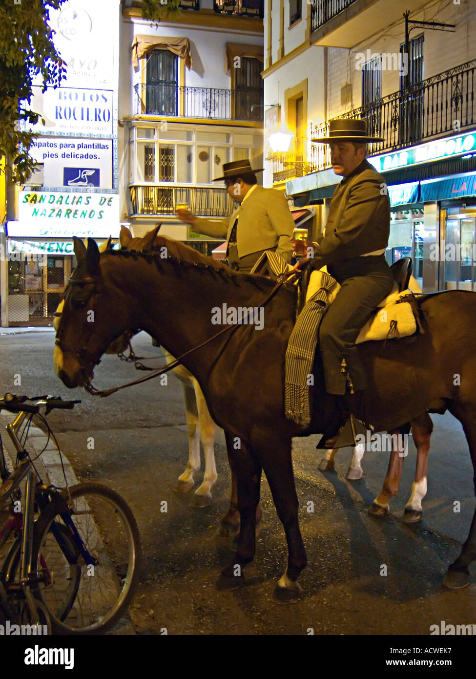 Due cavalieri sulla loro strada di casa dalla molla feria stop per una rilassante birra a tarda notte Siviglia Andalusia Spagna meridionale Foto Stock