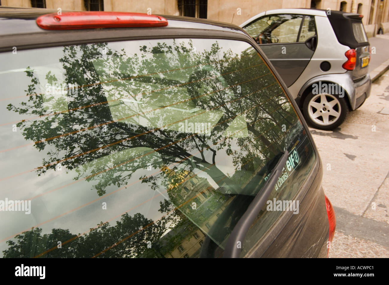 Colore immagine orizzontale di due piccole vetture economy parcheggiato sulla strada di Parigi Francia con la cupola di Les Invalides riflessa Foto Stock