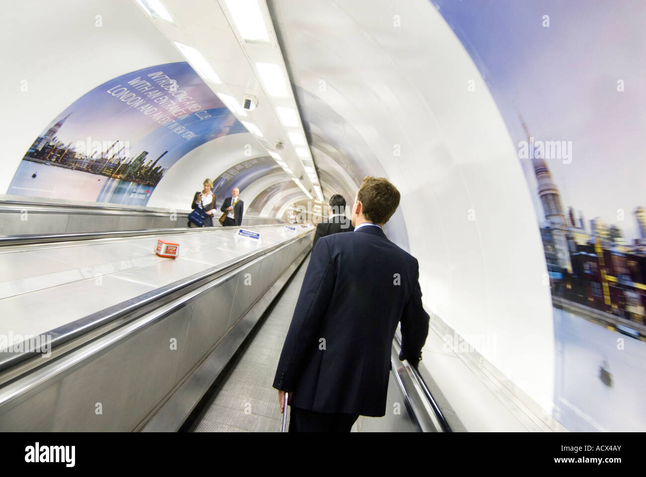 Pendolari su tapis roulants alla stazione della metropolitana di Londra Inghilterra REGNO UNITO Foto Stock