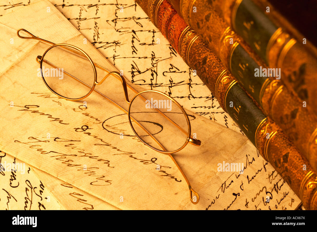 Oro antico vetri bordati di occhiali in appoggio sulle lettere scritte a mano con pelle di libri rilegati Foto Stock