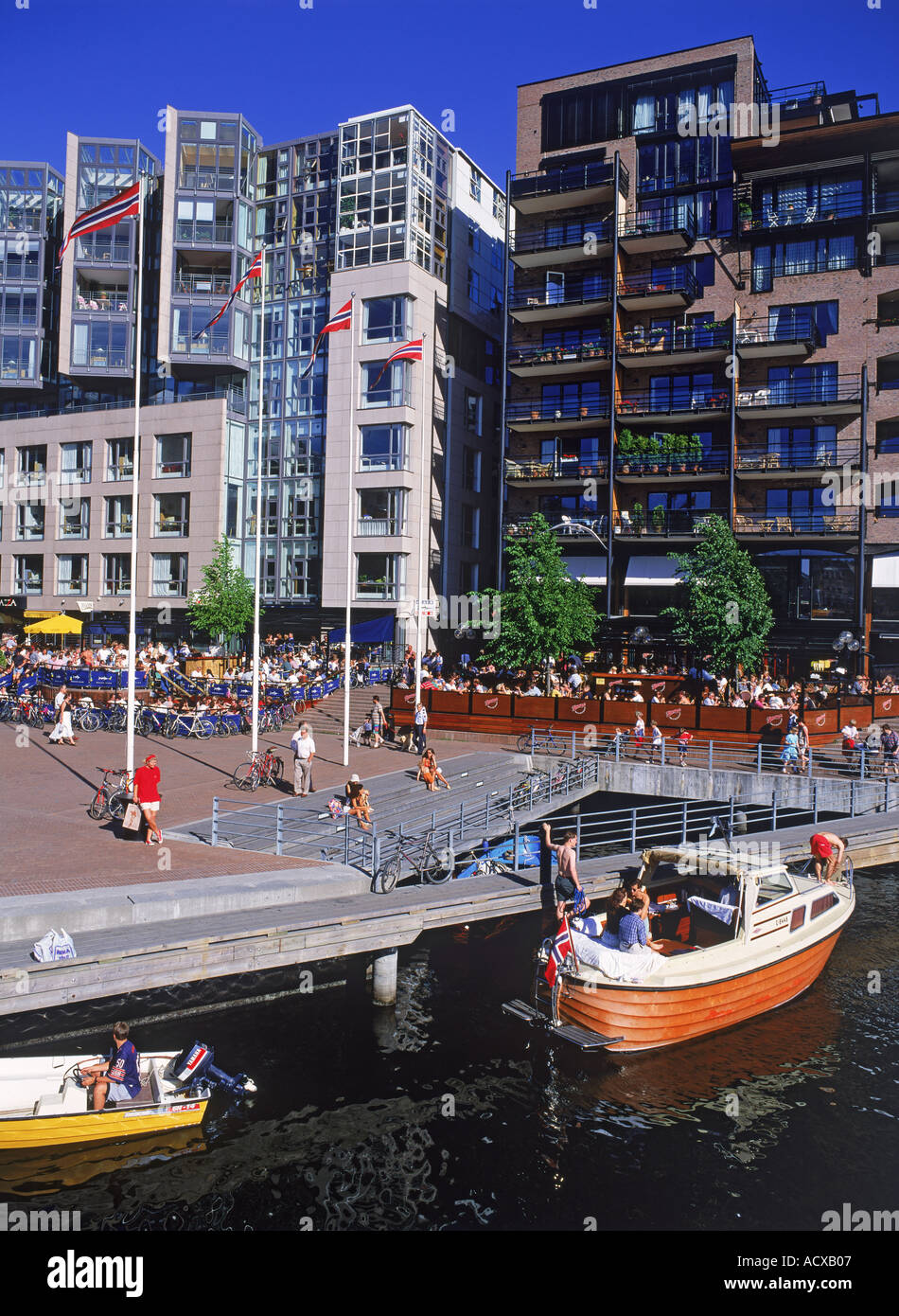 Ristoranti sul mare e canali con il passaggio di imbarcazioni presso Aker Pier in Oslo Foto Stock