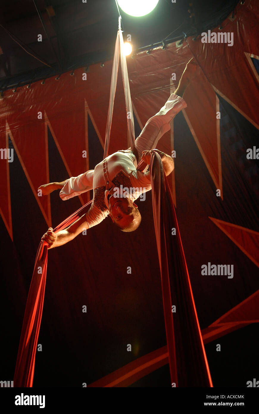 Circus acrobat performer tangled in drappi rossi Foto Stock