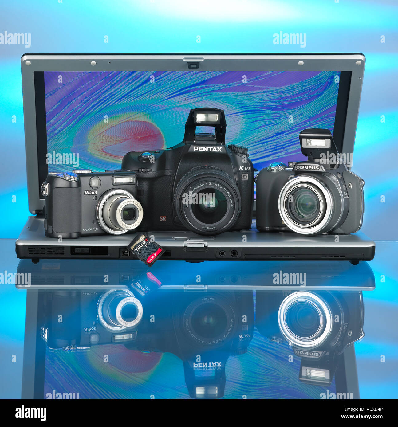Tre fotocamere digitali su un computer portatile con scheda di memoria Foto Stock