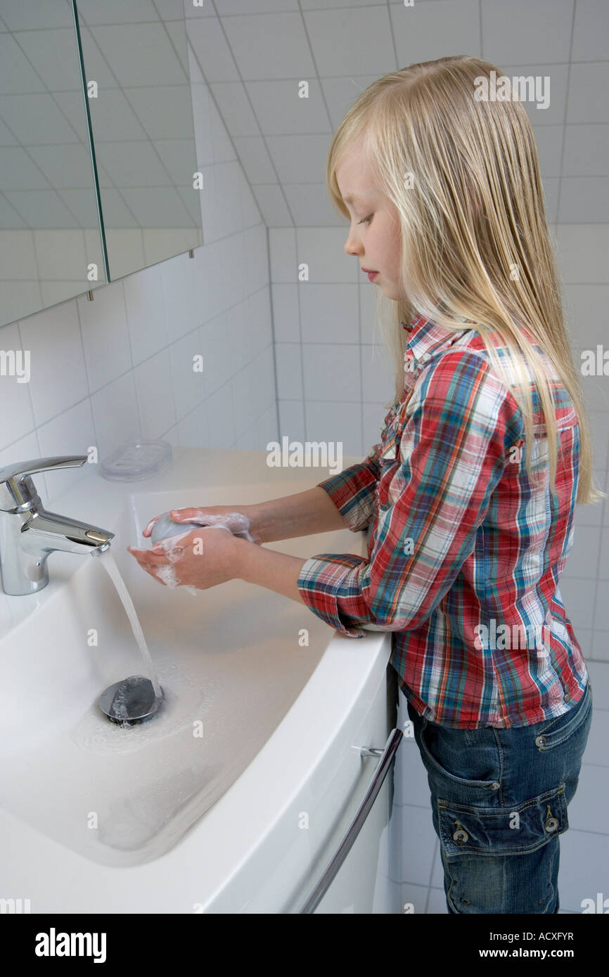 Ragazza bionda sta lavando le mani Foto Stock
