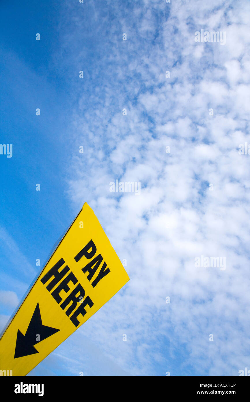 Qui a pagamento parcheggio auto segno nuovamente il cielo blu e nuvole bianche per il parcheggio auto a pagamento in Inghilterra UK GB Isole britanniche Foto Stock