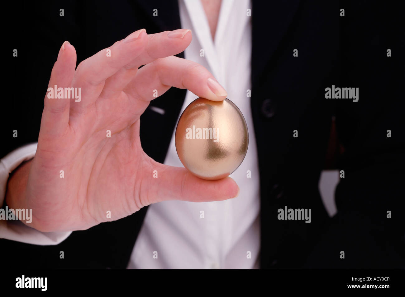 Donna che mantiene golden egg Foto Stock