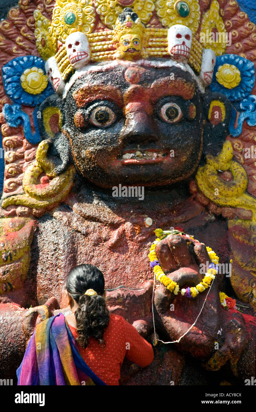 Donna fare un offerta a Kala Bhairab.Durbar Square.Kathmandu.Nepal Foto Stock