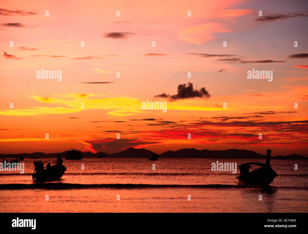 Un tramonto sagome barche a Krabi spiaggia sul Mare delle Andamane nel sud della Thailandia Foto Stock