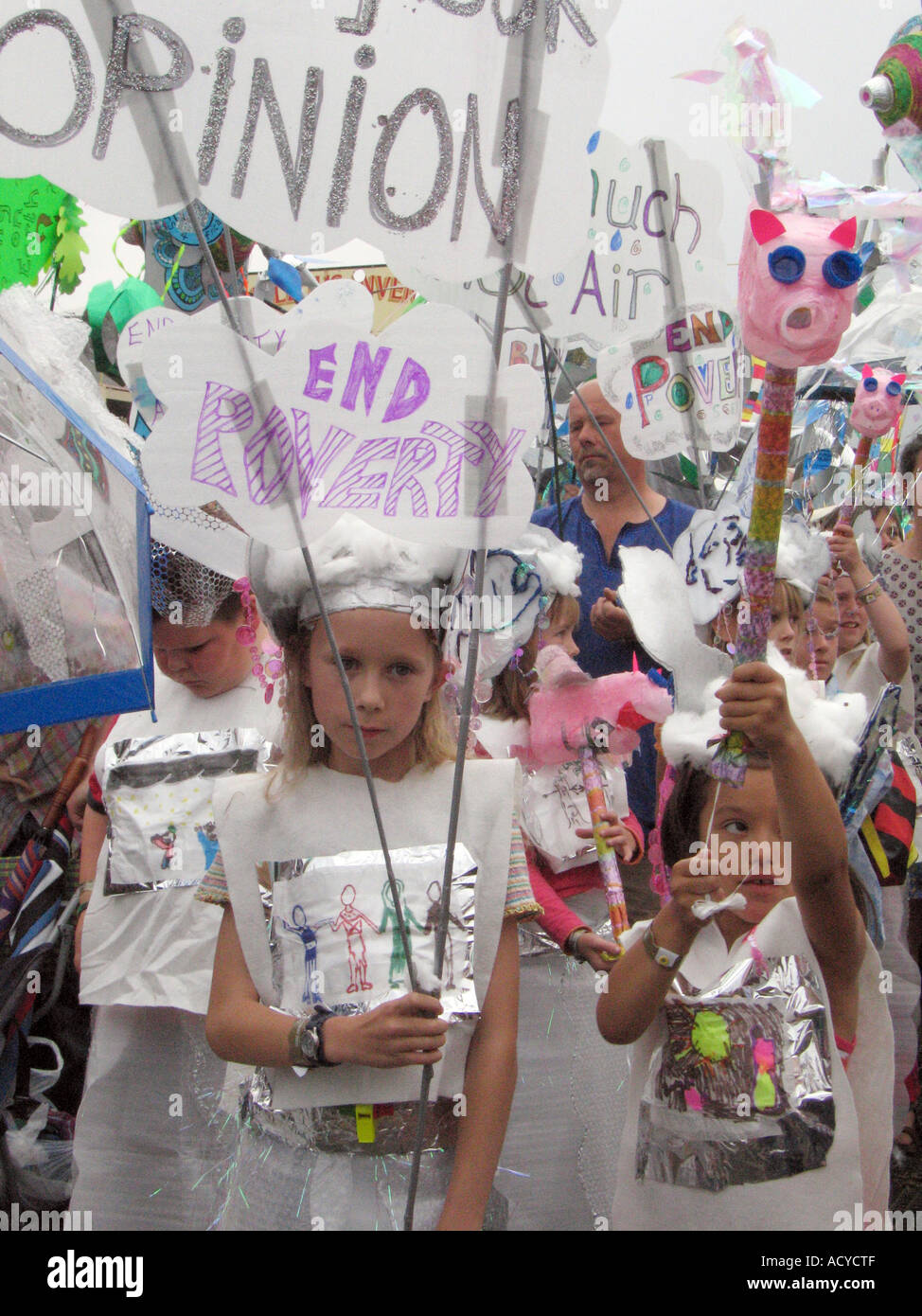 I bambini sfilano in costume per porre fine alla povertà al Womad Festival di musica Foto Stock