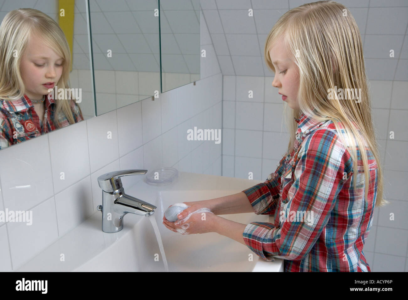 Ragazza bionda sta lavando le mani Foto Stock