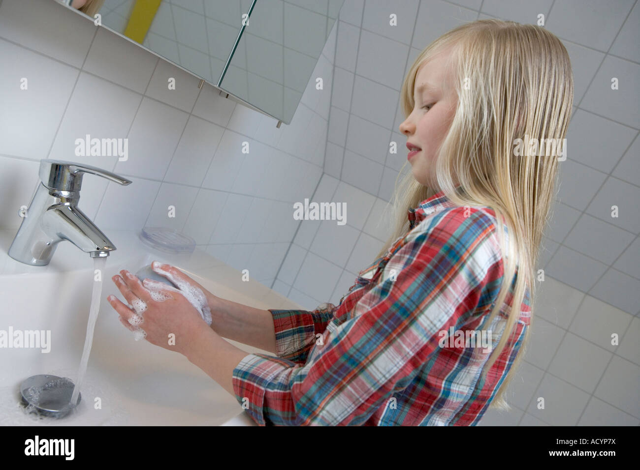 Ragazza bionda sta lavando le mani Foto Stock