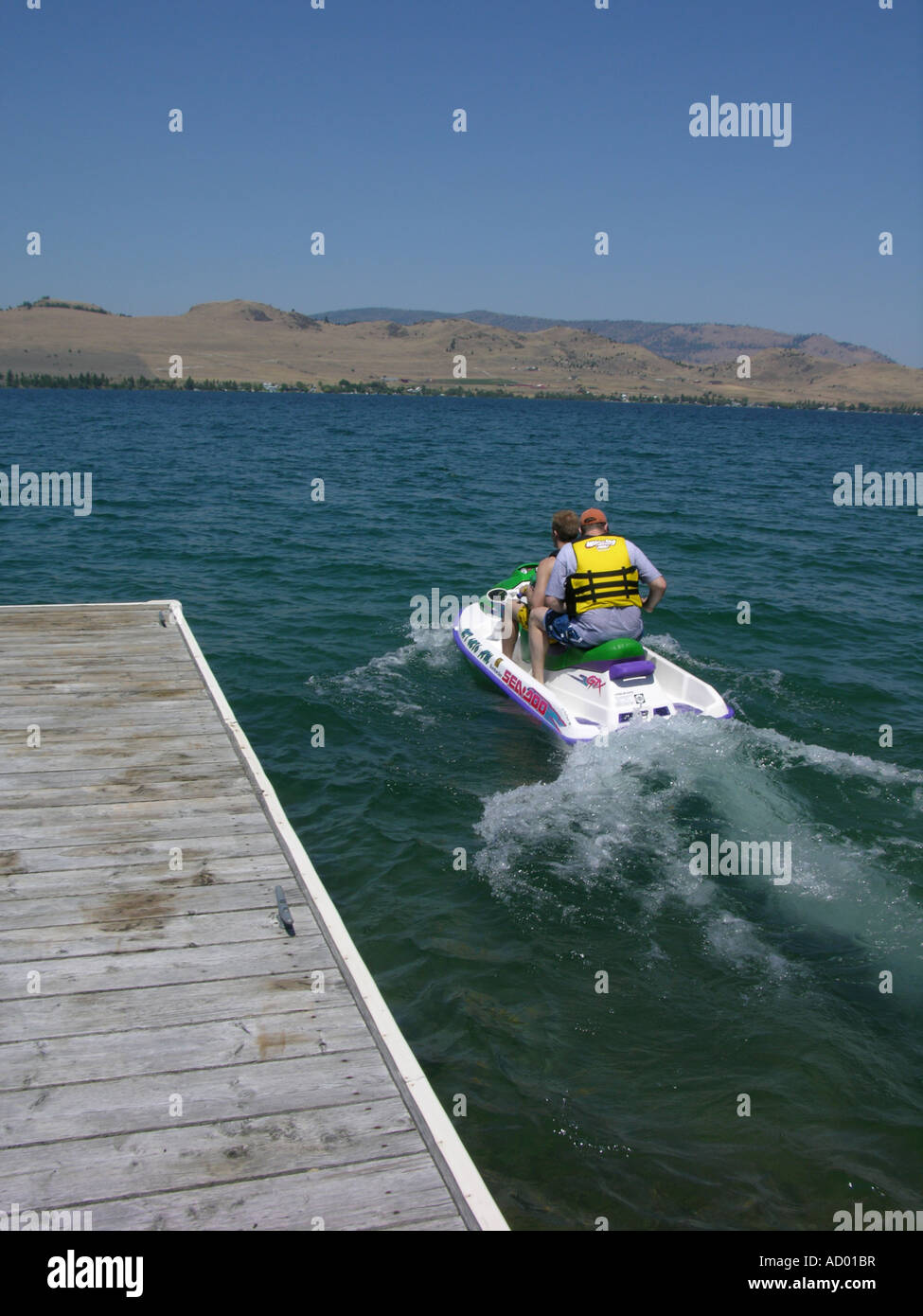 La gente di decollare dal dock sul jet ski. Foto Stock