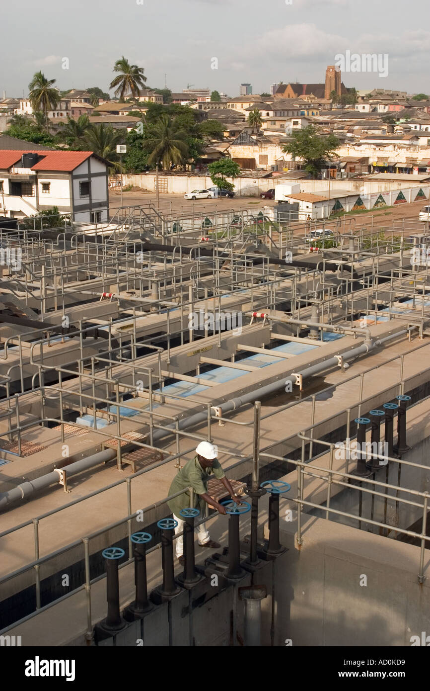 Operatore che regola le pompe dell'acqua durante la manutenzione durante l'aggiornamento e la pulizia dei lavori di depurazione Accra Ghana Africa occidentale Foto Stock