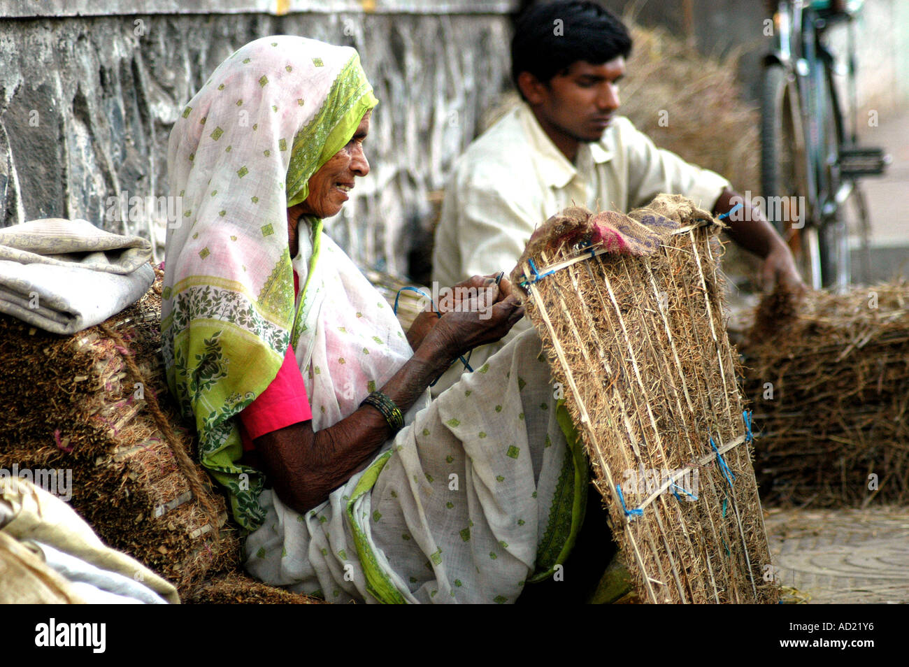 ASB73138 una donna stradale prepara stuoie di cocco per la protezione termica per i refrigeratori di acqua alla città di Nagpur Nagpur Maharashtra India Foto Stock