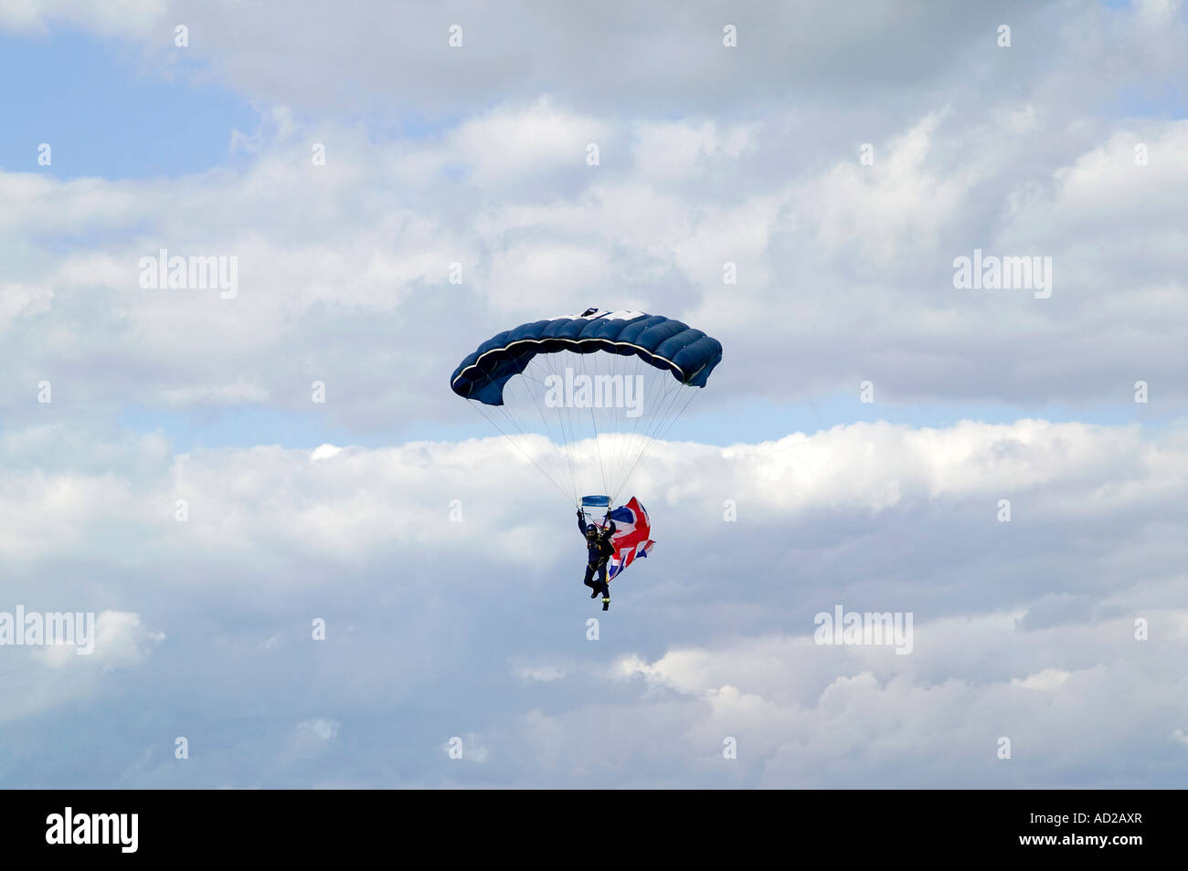 Parachutist con un Union Jack flag contro un blu cielo nuvoloso Foto Stock