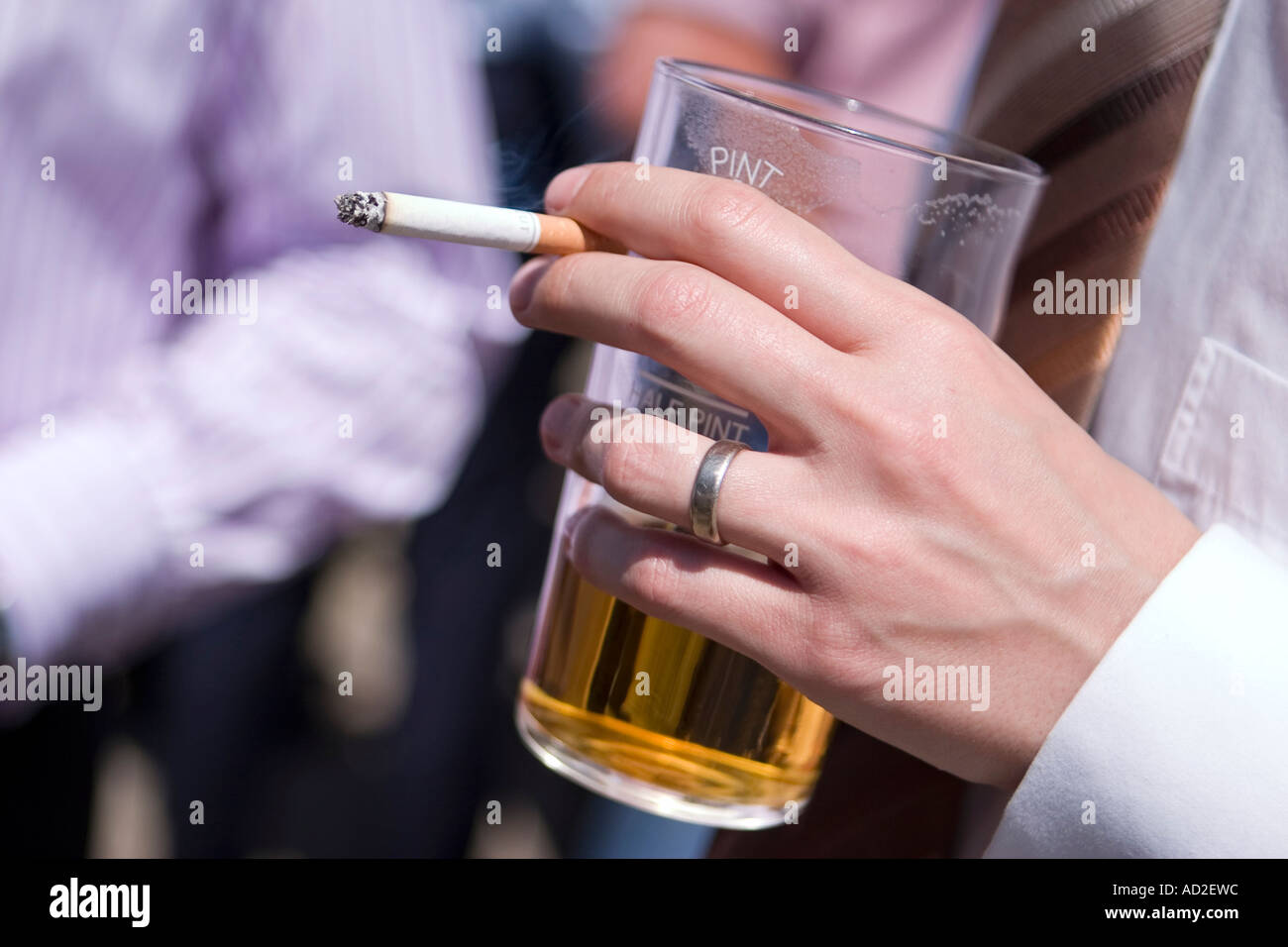 Immagine ravvicinata del giovane imprenditore gustando un drink e una sigaretta a pranzo nella città di Londra Foto Stock