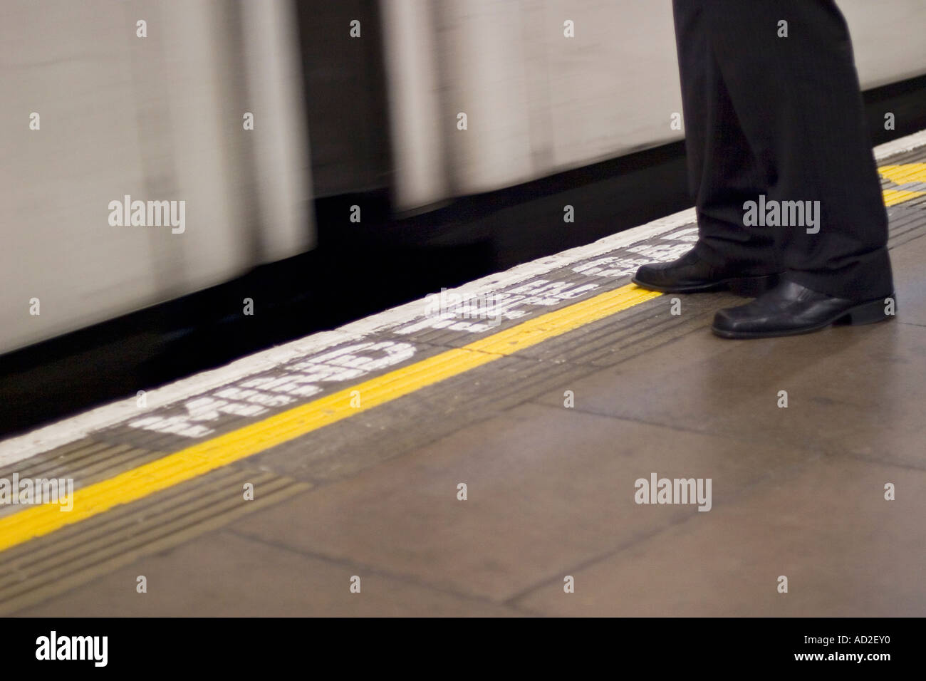 Giovane imprenditore sorge sulla metropolitana di Londra la piattaforma come tubo treno entra nella stazione Foto Stock