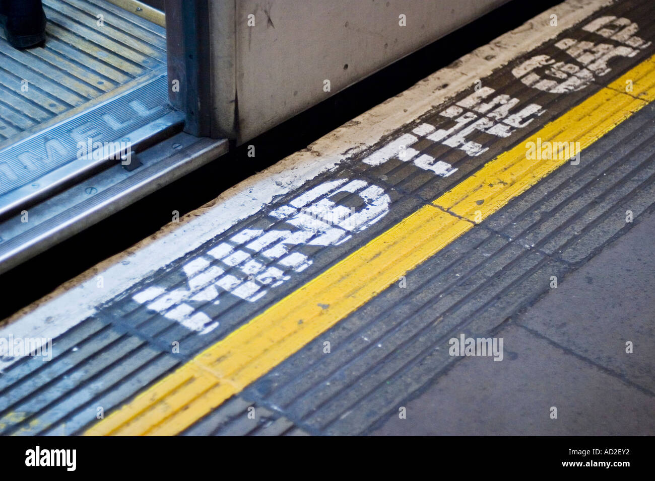 Tubo aperto lo sportello del treno sulla metropolitana di Londra la piattaforma con la mente il segno di spazio sul pavimento della piattaforma Foto Stock