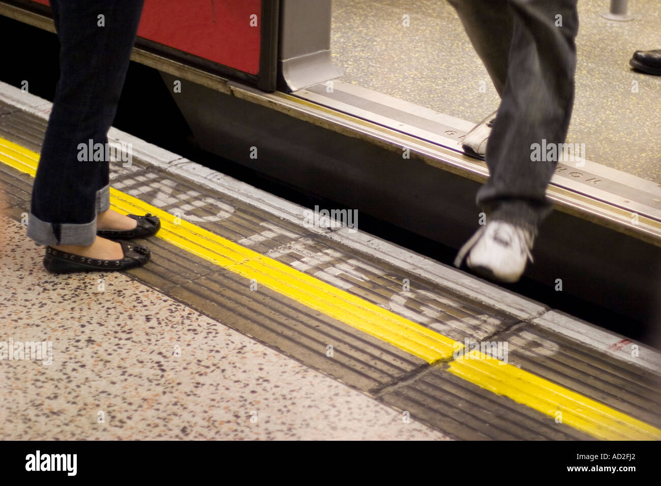 Giovane uomo passi fuori il tubo di treno sulla metropolitana di Londra platform Foto Stock