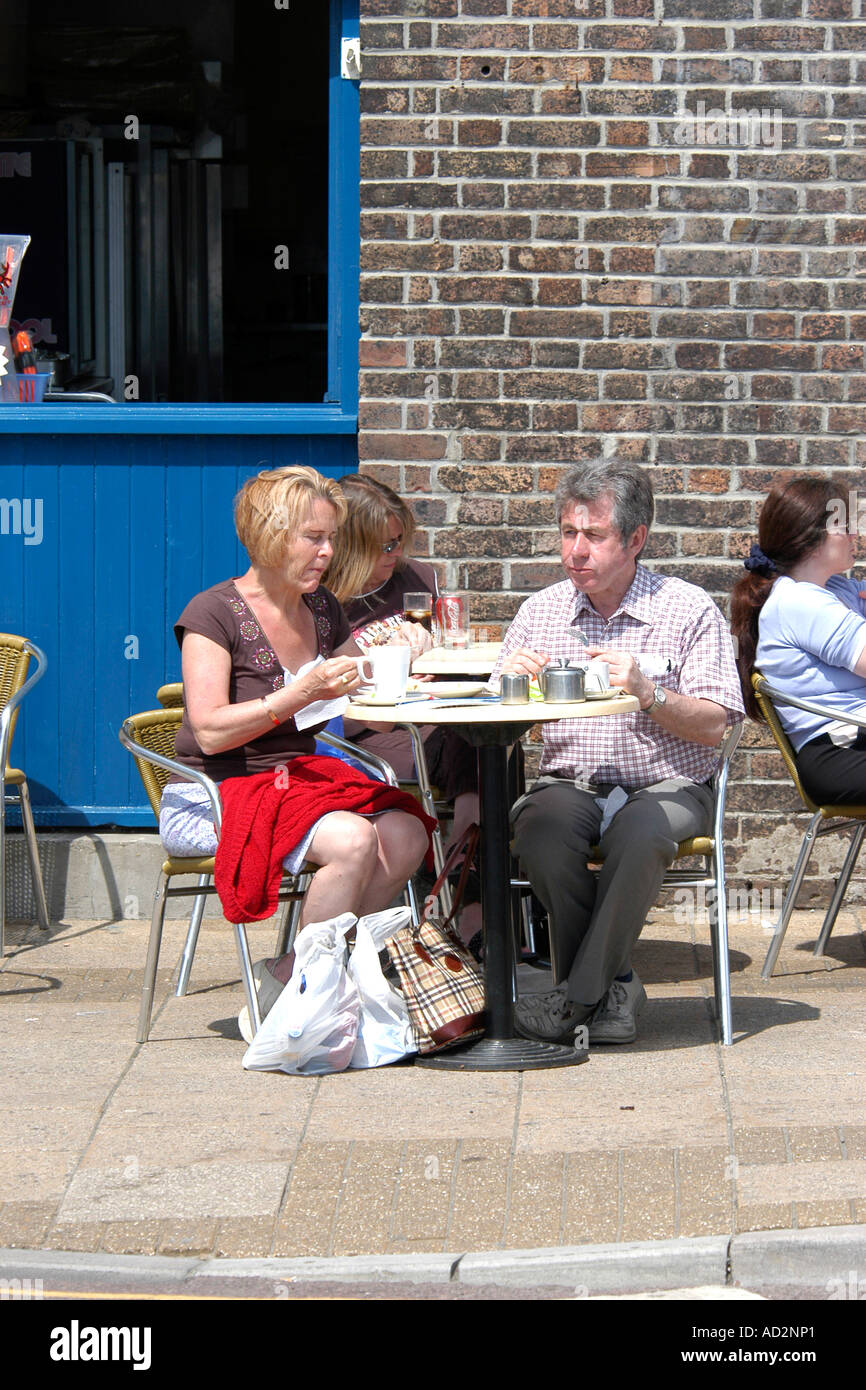 Persone di bere una tazza di caffè a un esterno in un bar durante la stagione estiva Foto Stock