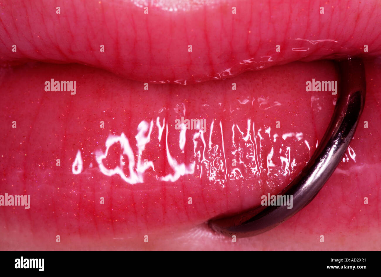 Il labbro inferiore piercing ad anello sulla carta lucida labbra Foto stock  - Alamy
