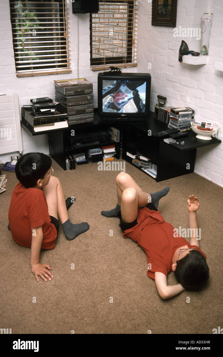 Due fratelli rilassarsi di fronte alla televisione Foto Stock