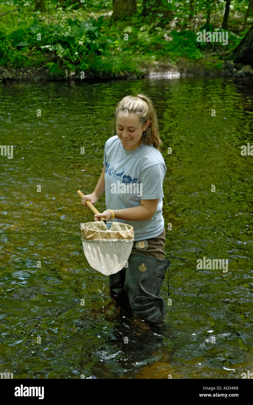 Ragazza adolescente utilizzando net di campionamento di acqua di fiume per pesci e invertebrati indicatori biologici della qualità dell'acqua Foto Stock