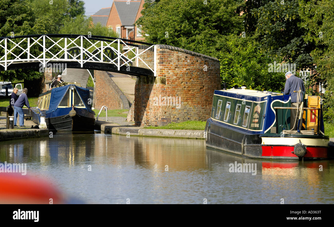 Narrowboats negoziando la serratura a giunzione Hawkesbury, North Oxford Canal, England, Regno Unito Foto Stock