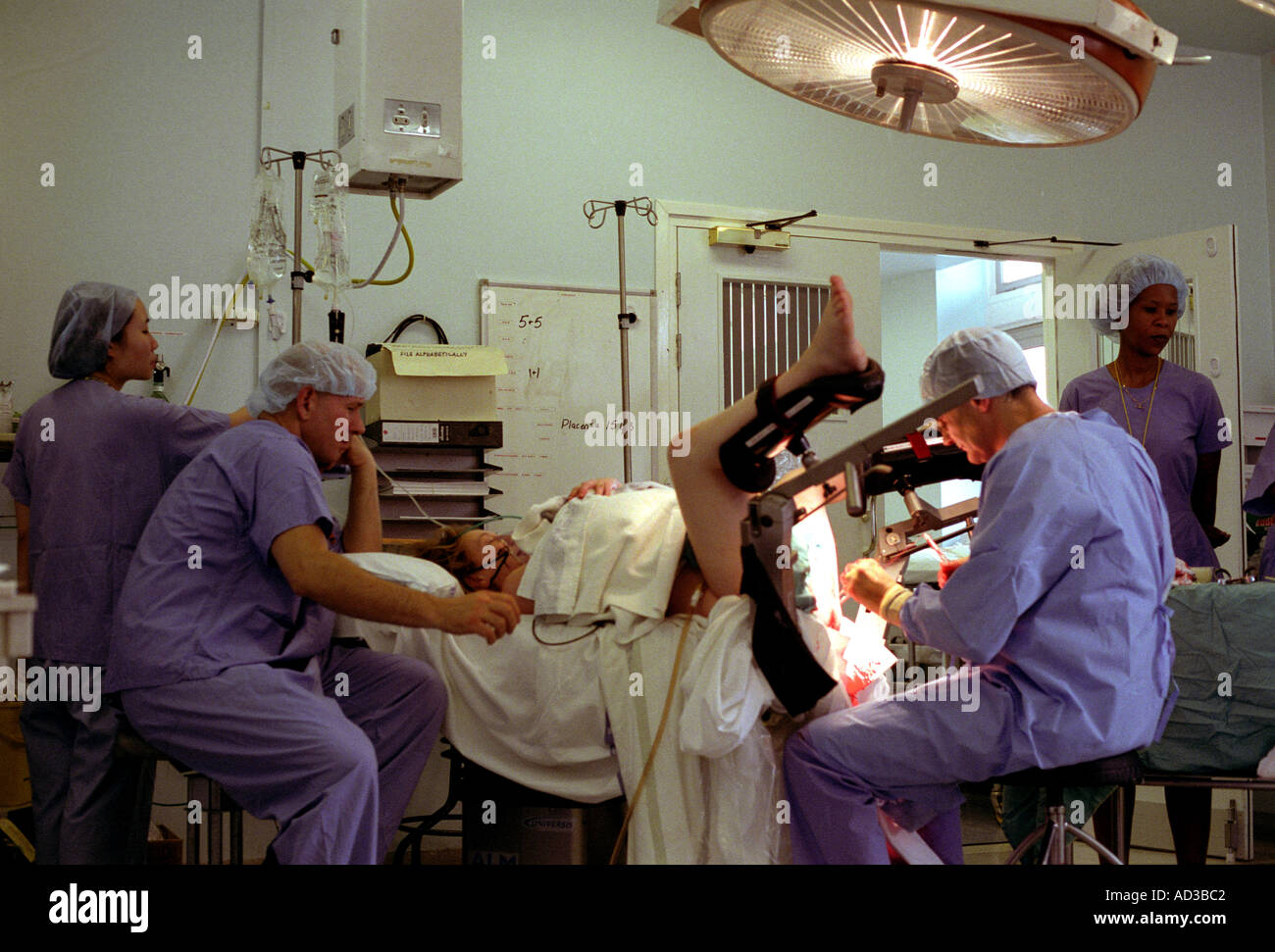 La donna in posizione di litotomia essendo cuciti dopo il forcipe consegna. Foto Stock