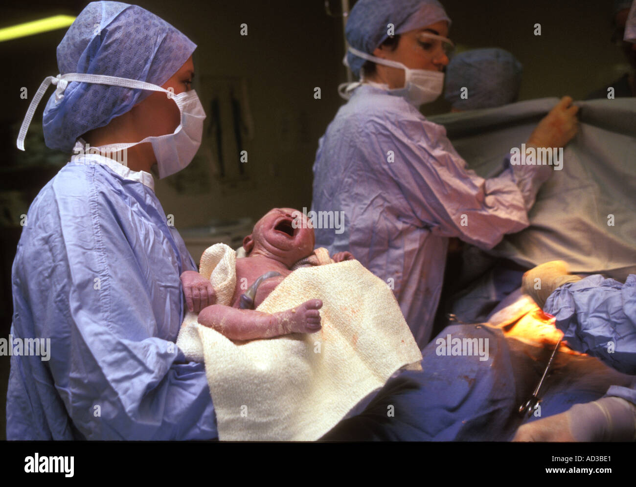 Neonato essendo tenuto dalla levatrice è appena stata consegnata da taglio cesareo. Foto Stock