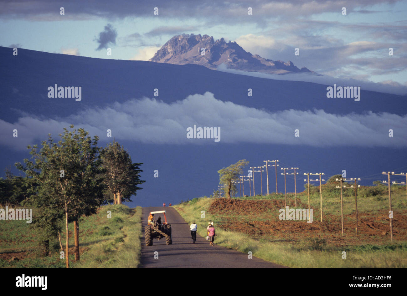 Il trattore guidando lungo la strada a Moshi durante la stagione della semina, Mawenzi (5.149m) sullo sfondo; Tanzania Foto Stock